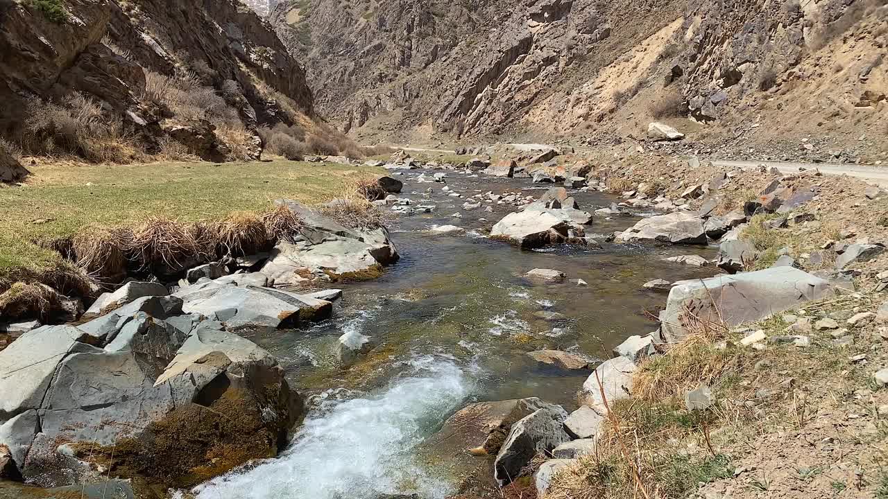 美丽的景色最纯净的山冷溪清澈的水。这条河沿着公路流入一个风景如画的峡谷。视频素材