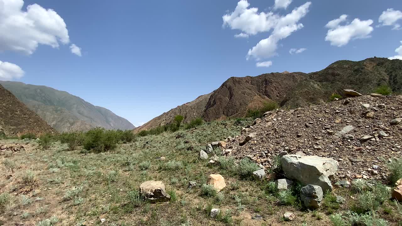 吉尔吉斯斯坦山谷的美丽全景。令人惊叹的山地景观。从一条肮脏的棕色暴雨河的高处俯瞰。视频素材