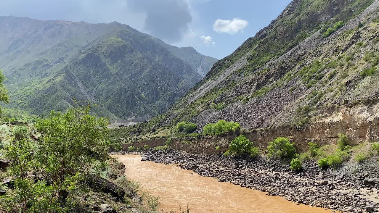 从一条肮脏的棕色暴雨河的高处俯瞰。吉尔吉斯斯坦山谷的美丽全景。令人惊叹的山地景观。视频素材