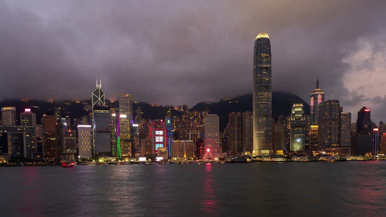 4K延时拍摄香港城市的昼夜全景。从维多利亚港观景台俯瞰日落后灯火通明的金融区高层和住宅楼视频素材