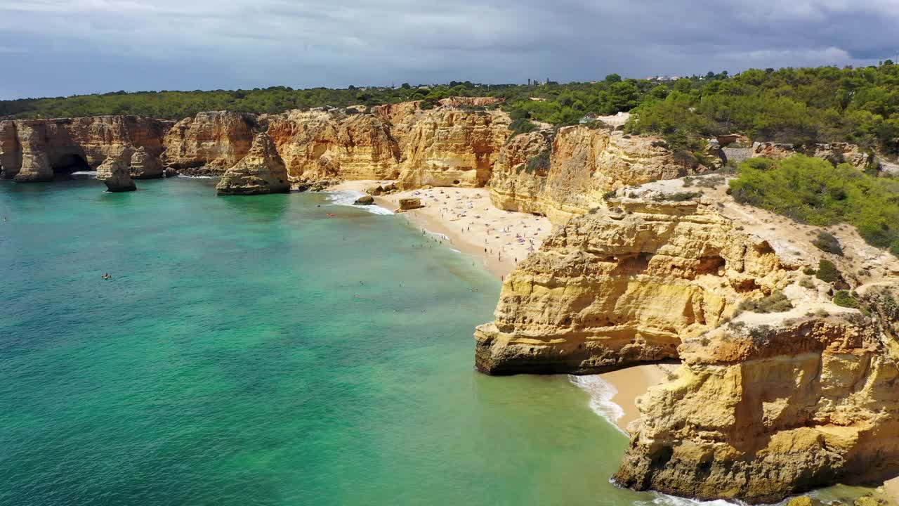 葡萄牙阿尔加维的海滨海滩。海军海滩(Praia da Marinha)在海滩上飞行的海鸥，位于大西洋沿岸的拉戈阿市，阿尔加维。视频素材