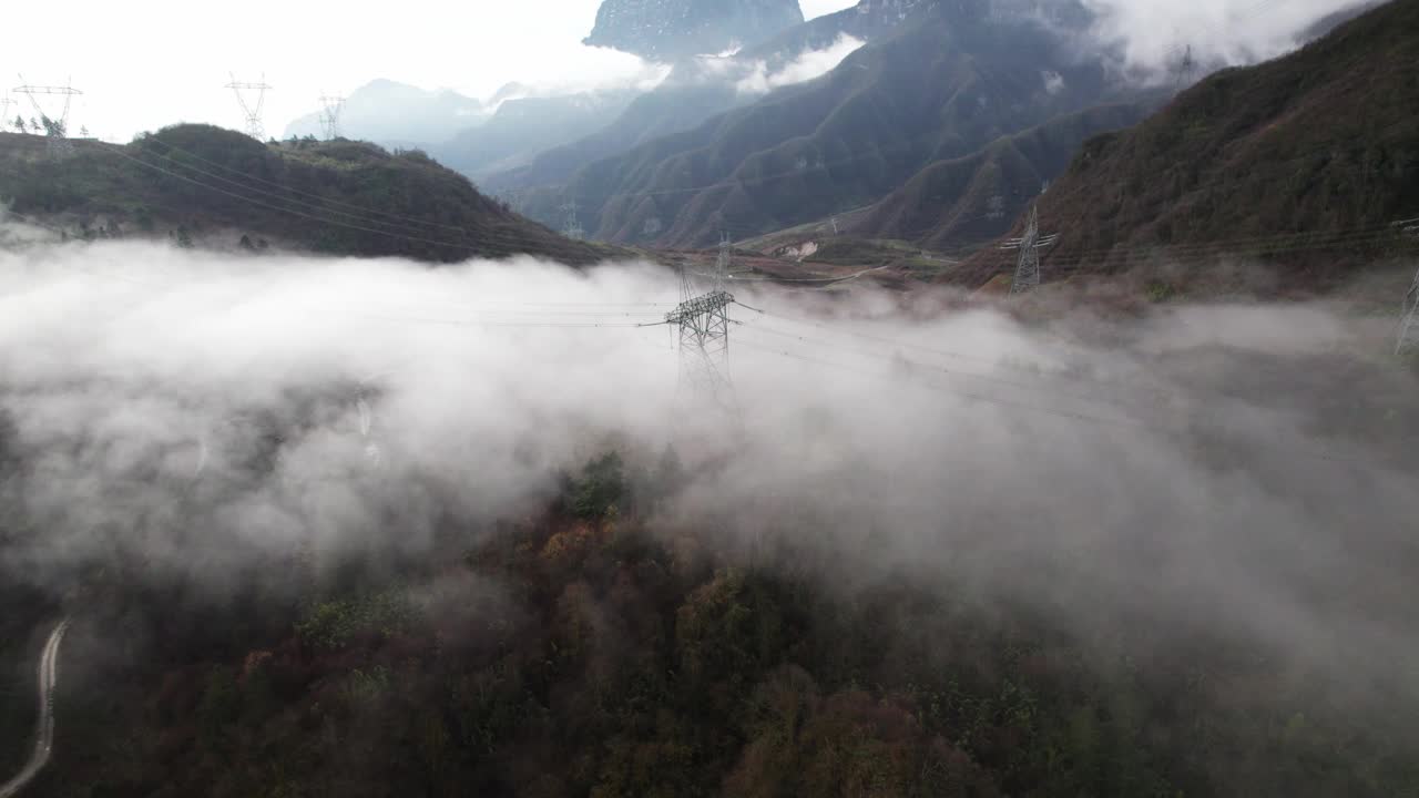 在雾蒙蒙的天气里，无人机从森林山丘上的传输塔上俯瞰视频素材