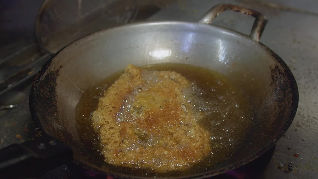 烹饪泰式食物，在热油锅中煎煮酥脆鲶鱼沙拉，在沸油中煎炸鲶鱼变得又干又脆视频素材