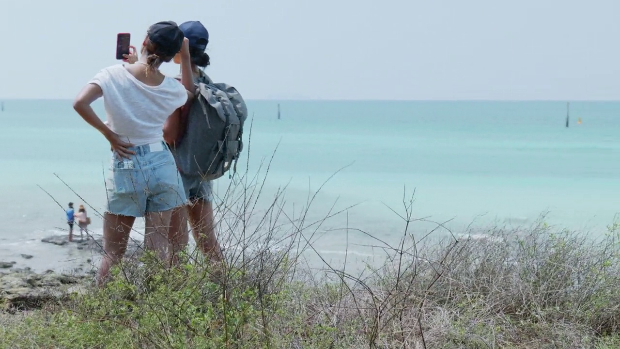 女徒步旅行者站在观景台眺望大海视频素材