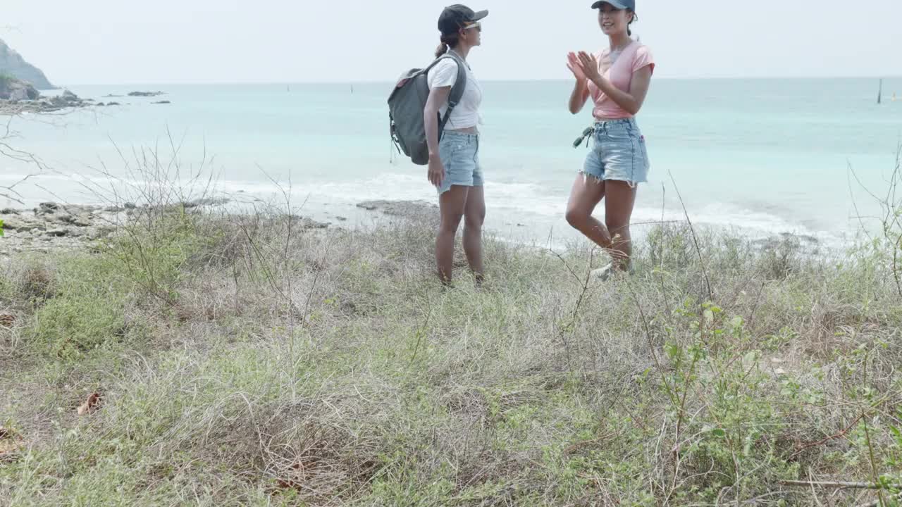 女徒步旅行者站在观景台眺望大海视频素材