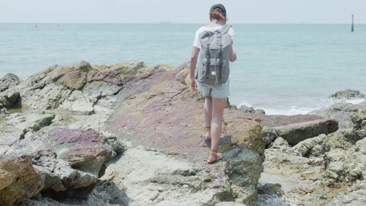 女徒步旅行者站在观景台眺望大海视频素材