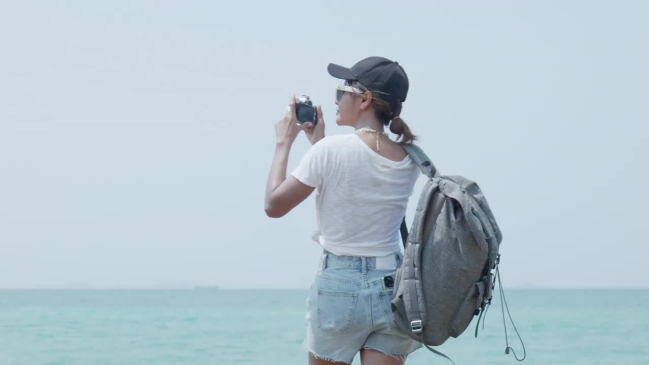 女徒步旅行者站在观景台眺望大海视频素材