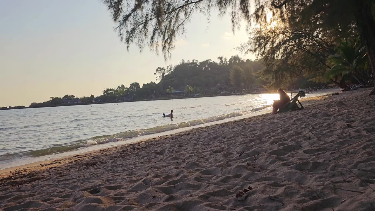 在阳光明媚的日子里，快乐的亚洲老人在热带海滩上的太阳椅上感到自由和放松。退休老人享受户外的生活方式，旅游自然海洋在暑假假期。视频下载