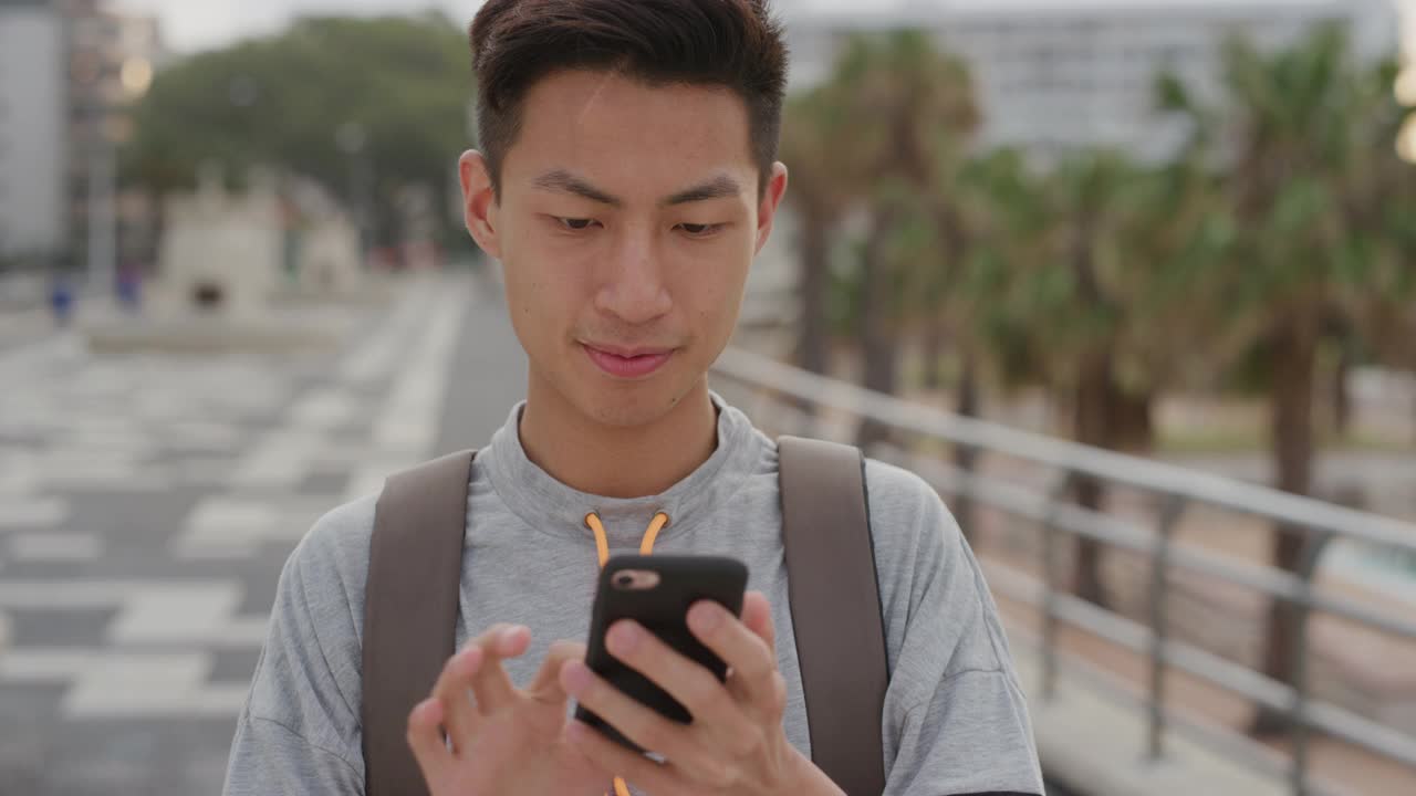 年轻的亚洲男子游客用智能手机拍照度假体验享受分享摄影微笑愉快的手机拍照技术视频素材