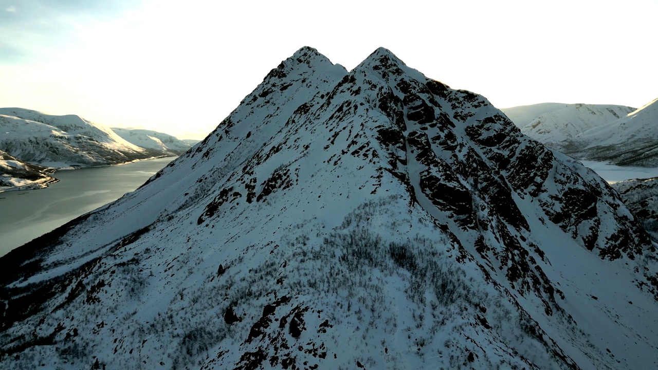 航拍的岩石雪山的顶峰，背景是一条河视频素材