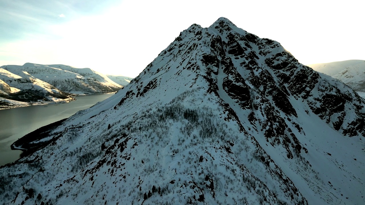 航拍的岩石雪山的顶峰，背景是一条河视频素材