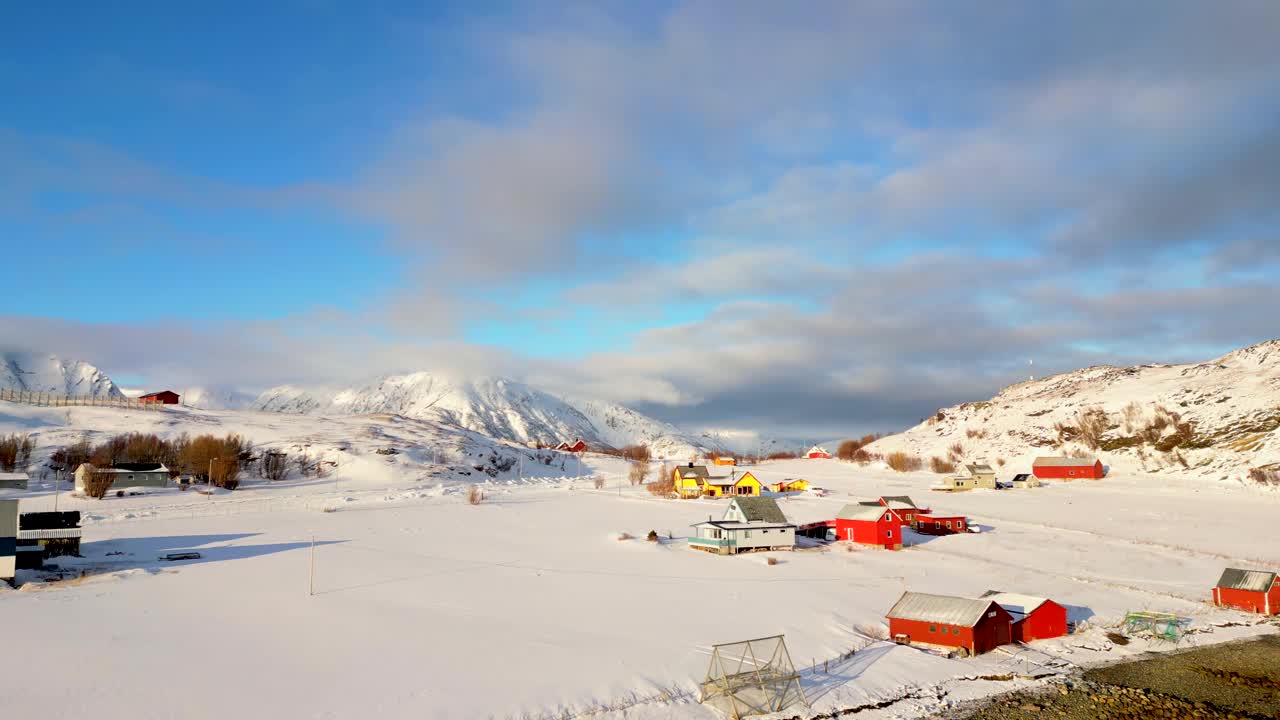 航拍视频显示一条平静的河流，岸边多岩石的雪山上有建筑物视频素材