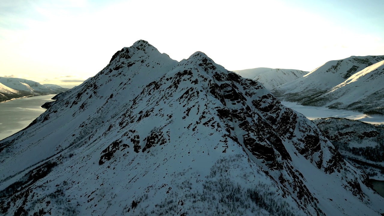 航拍的岩石雪山的顶峰，背景是一条河视频素材