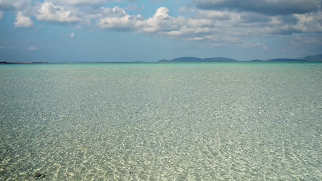 美丽的景观，平静的蓝绿色海水和山在地平线上的晴天。视频素材