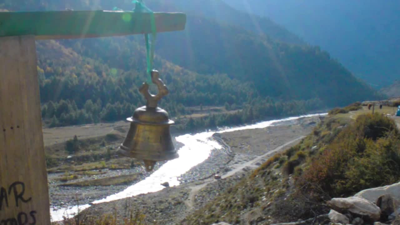 一座祈祷钟悬挂在山的背景上。视频素材