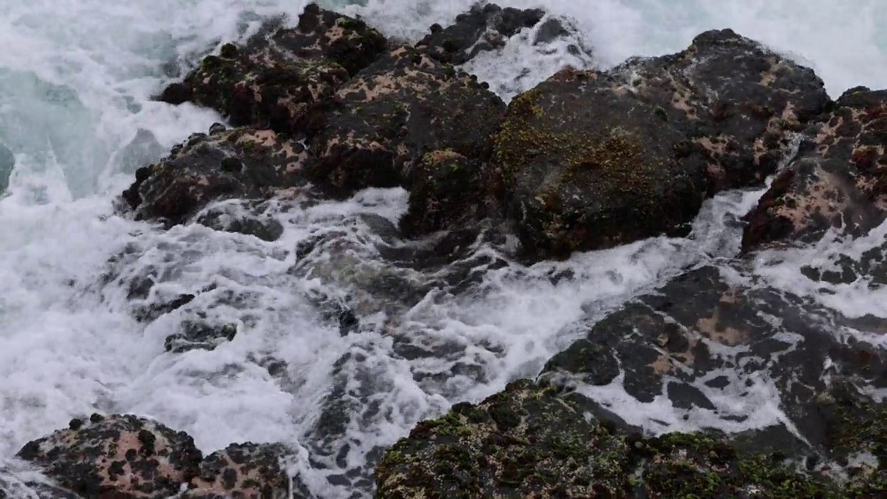 特写视角:海浪冲击岩石海岸线的俯视图视频素材