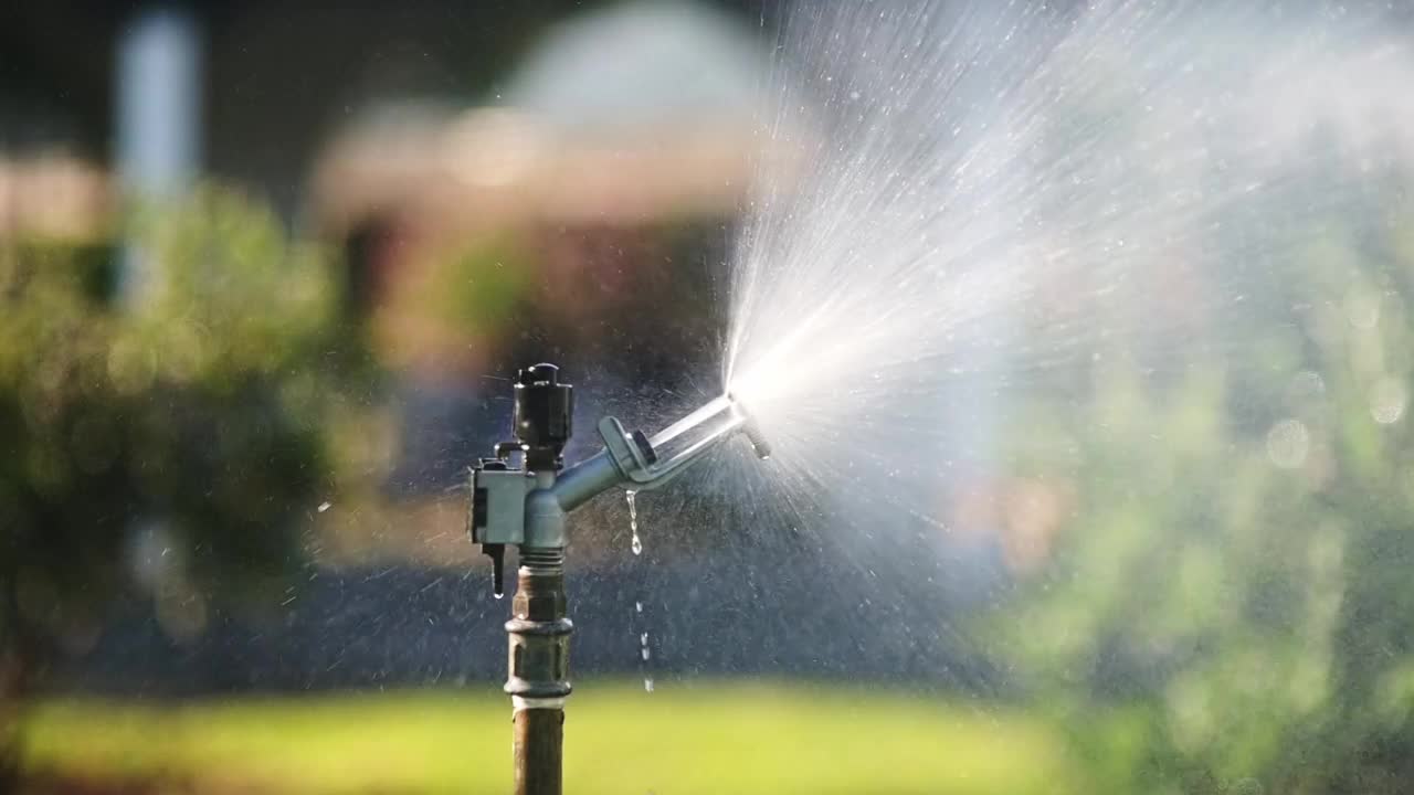 公园里的花园洒水器。园艺设备。给院子里的草浇水视频素材