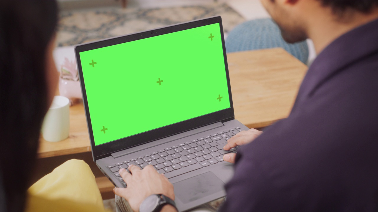 年轻夫妇使用绿屏笔记本电脑:浏览服装、产品销售网站，选择最适合的网上购物。女朋友和男朋友喜欢一起购物。特写镜头视频素材