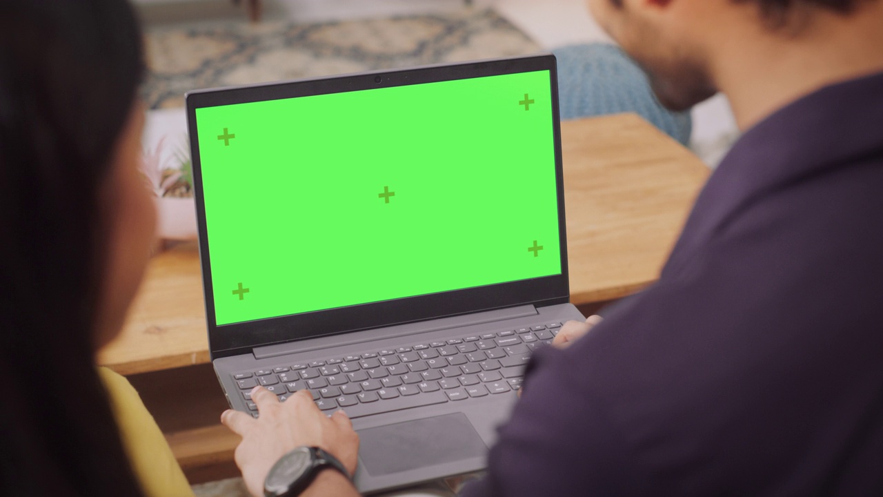 年轻夫妇使用绿屏笔记本电脑:浏览服装、产品销售网站，选择最适合的网上购物。女朋友和男朋友喜欢购物。特写镜头视频素材