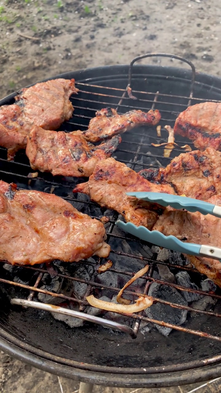 浓郁的香气和风味烧烤猪肉牛排在街边烧烤。多汁的猪肉牛排，在后院熟练烹饪。视频素材