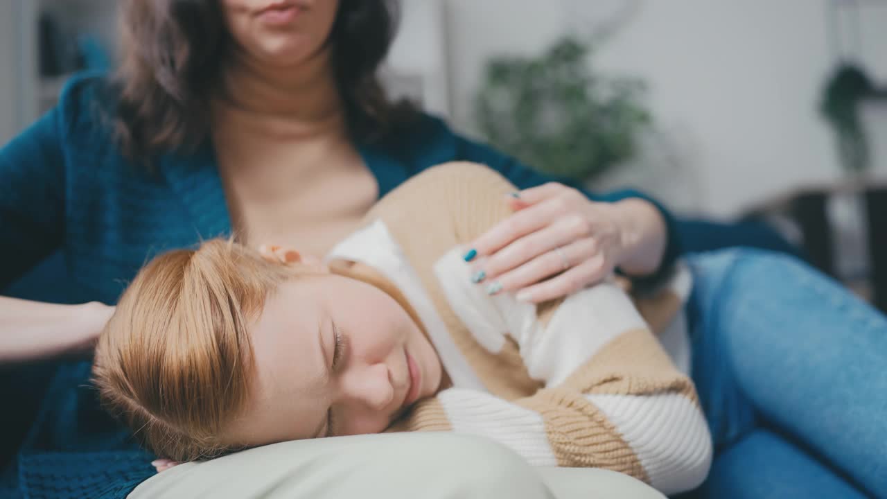 一个女人抱着她哭泣的十几岁的女儿的特写，在学校遇到的问题视频素材