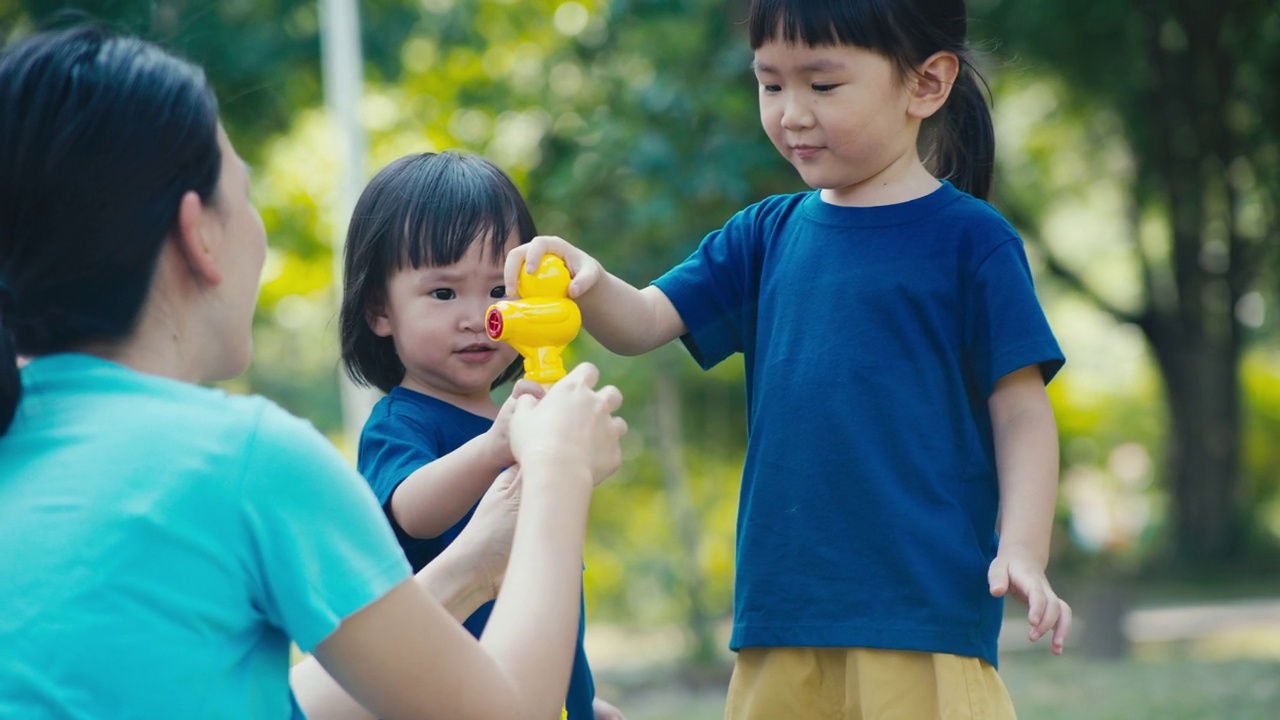 一个小孩子在公园里玩肥皂泡。视频素材