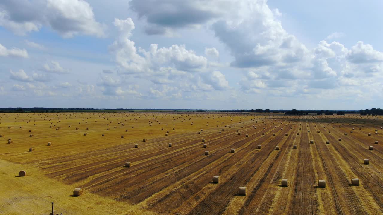 在一个阳光明媚的夏日，田野的航拍画面，很多干草捆，4k视频素材