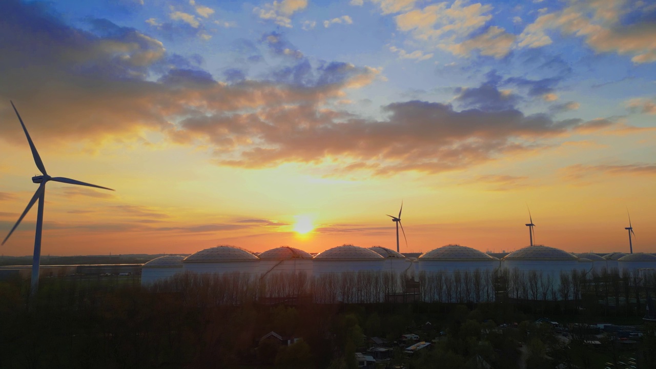 夕阳下田野里风力涡轮机的美丽景色视频素材