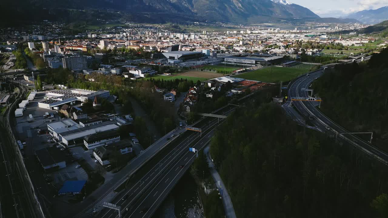 奥地利因斯布鲁克的城市景观，有汽车和山脉的空中景观镜头视频素材