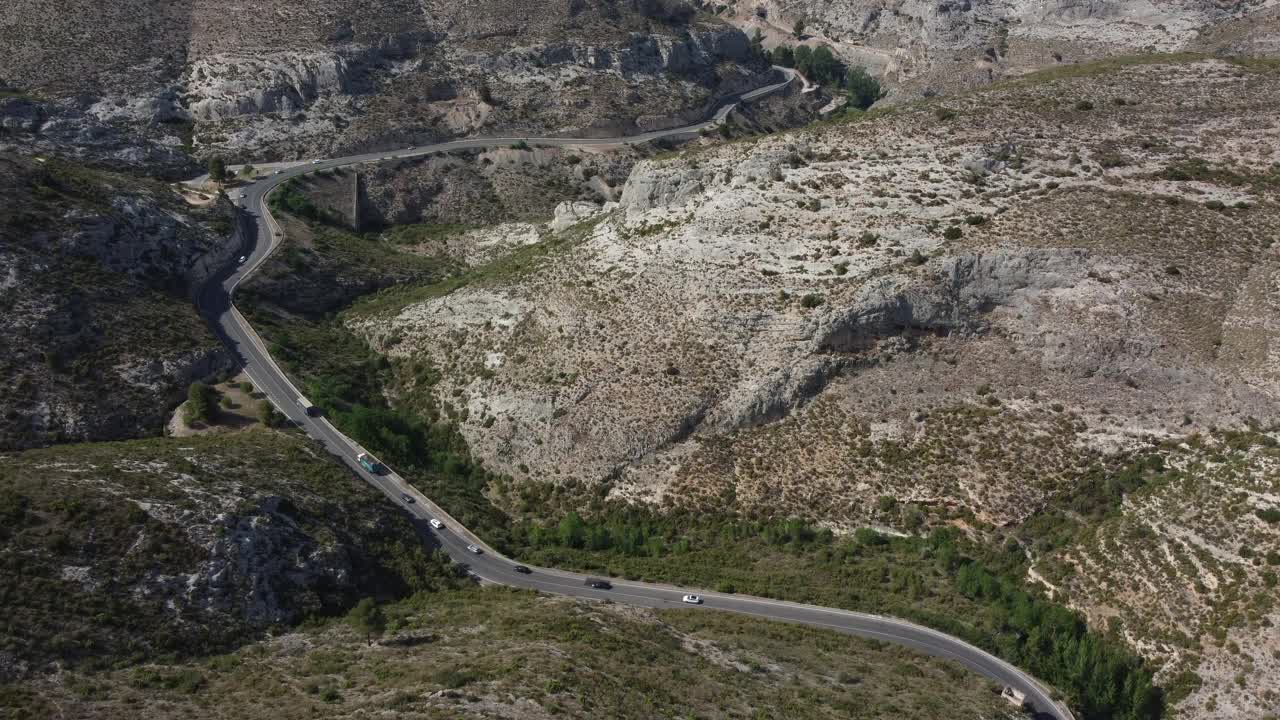 鸟瞰图，汽车和卡车行驶在弯曲的山路上。视频素材