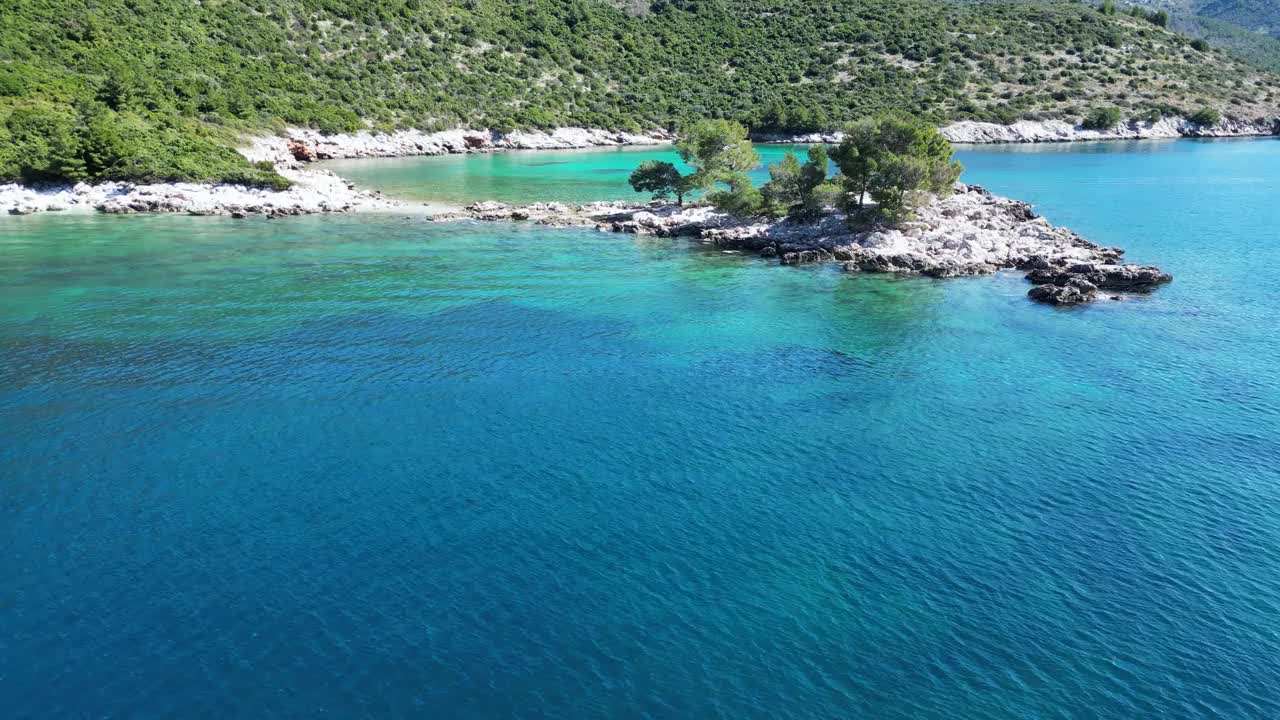 航拍的海洋和岩石山脉覆盖着树木的海岸视频素材