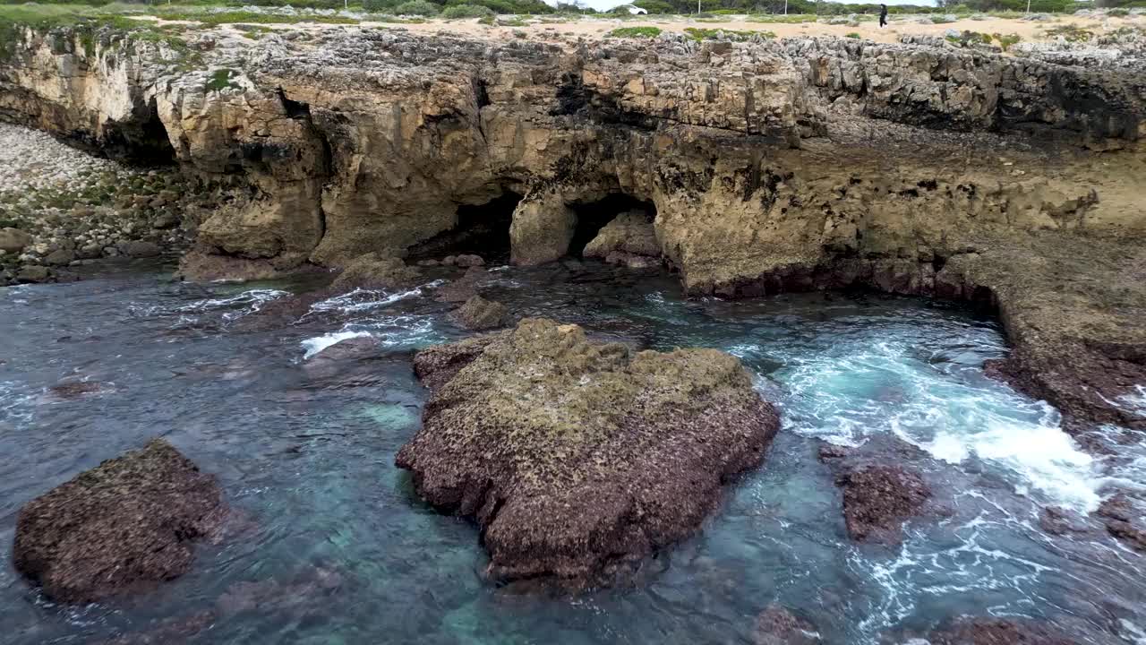 航拍的海洋和岩石山脉覆盖着树木的海岸视频素材