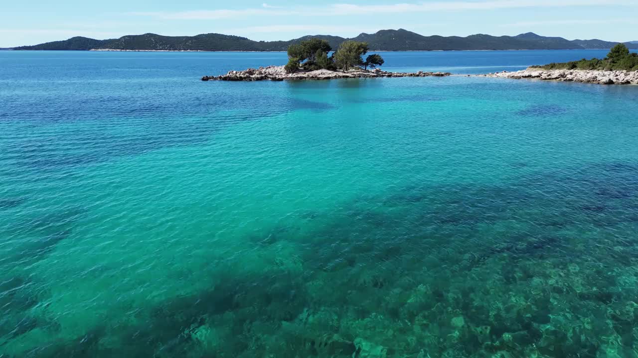 航拍的海洋和岩石山脉覆盖着树木的海岸视频素材