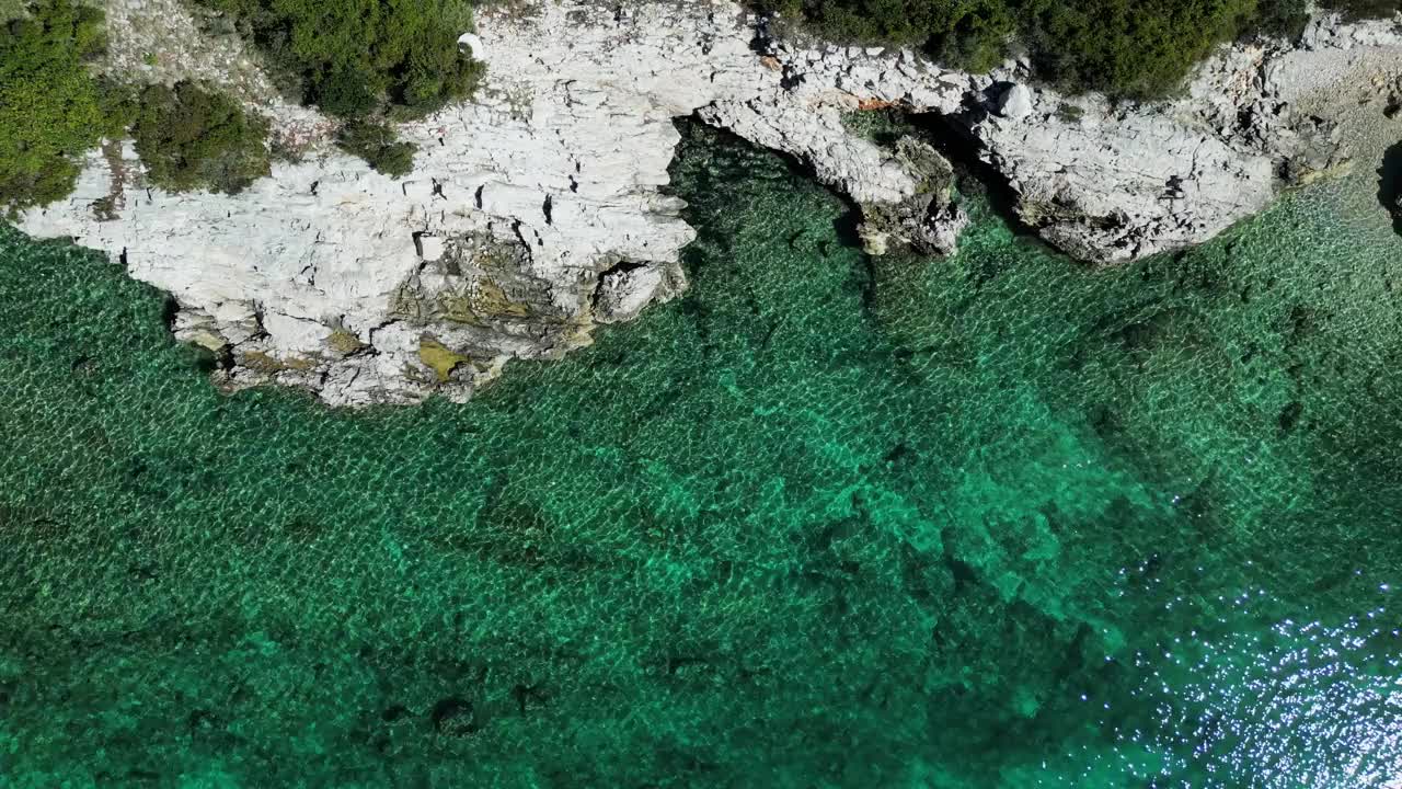 空中俯瞰的视频，海洋和岩石山脉覆盖着树木在海岸视频素材