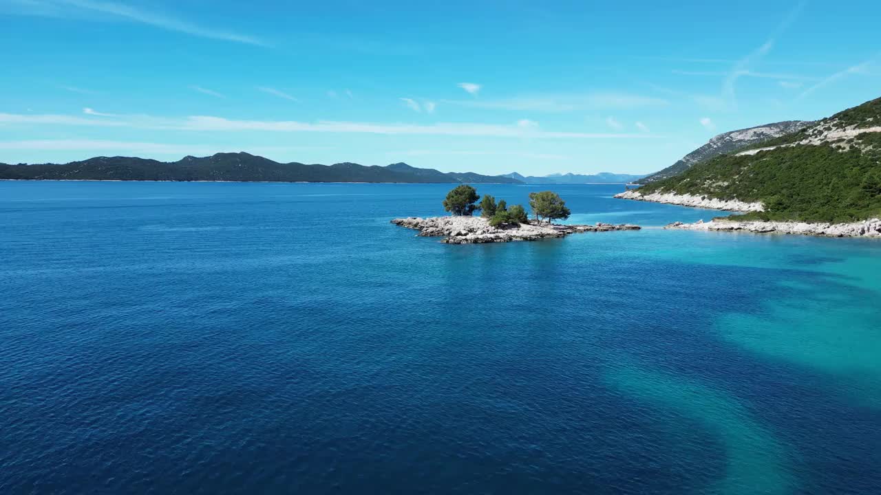 航拍的海洋和岩石山脉覆盖着树木的海岸视频素材