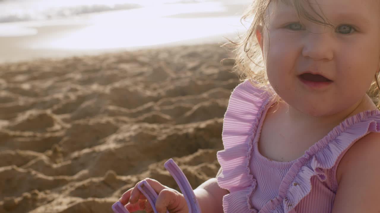 可爱的女婴在海边享受夏日夕阳下的海滩假期视频素材