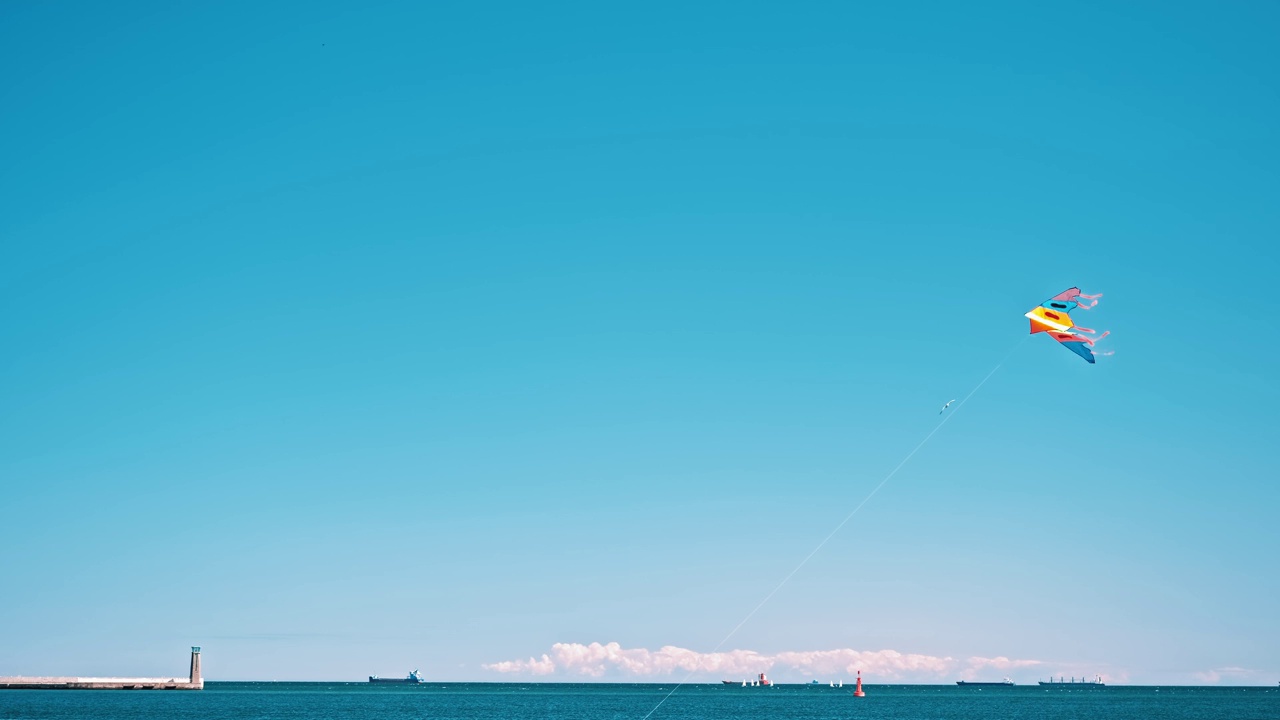 五颜六色的系绳风筝漂浮在空中，在海边的强风中飞翔视频素材