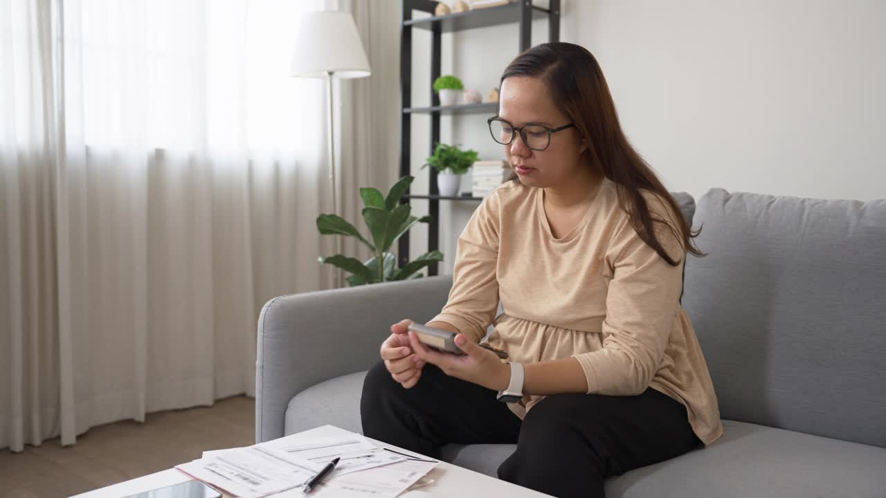 担心的女人管理和计算账单支付。家庭理财视频素材