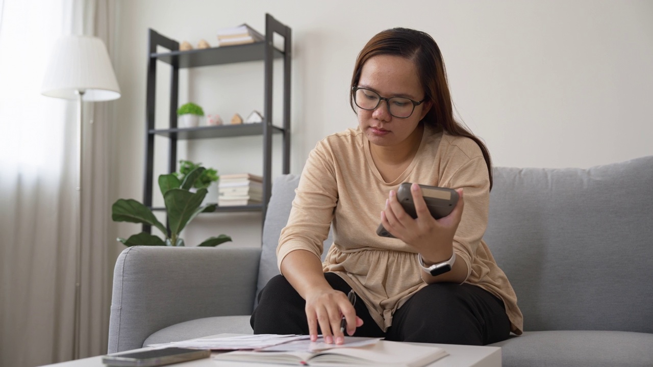 担心的女人管理和计算账单支付。家庭理财视频素材