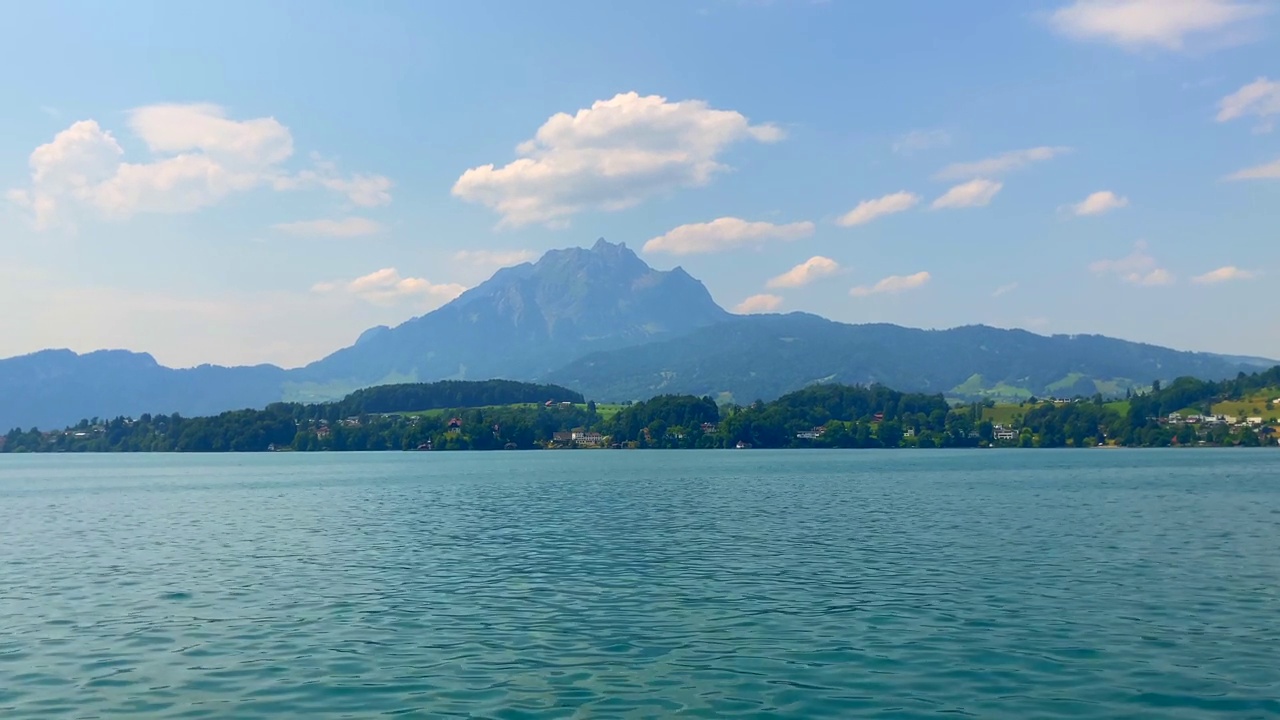 在一个阳光明媚的夏日里，在卢塞恩湖与皮拉图斯山顶美景一起旅行视频素材