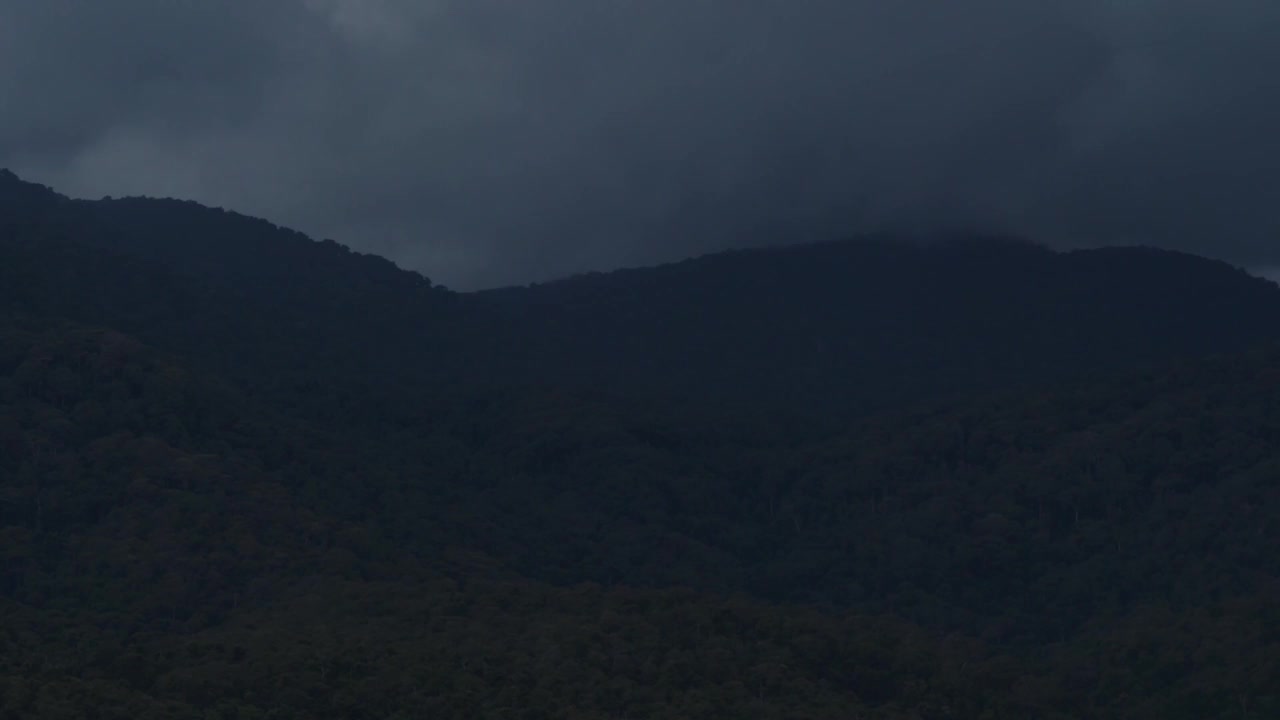 快速特写b-roll场景:乌云密布的天空，暴雨在山上倾盆而下，雨季阴云密布的恶劣天气视频素材