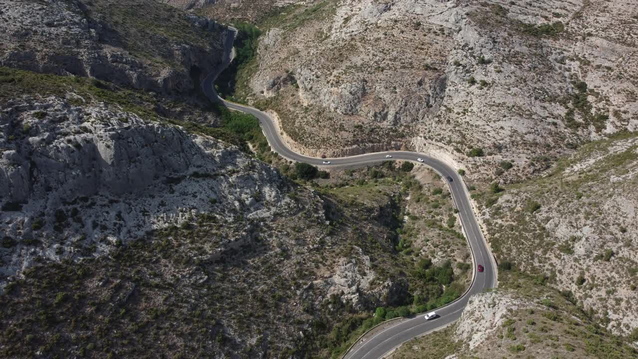 鸟瞰图，汽车和卡车行驶在弯曲的山路上。视频素材