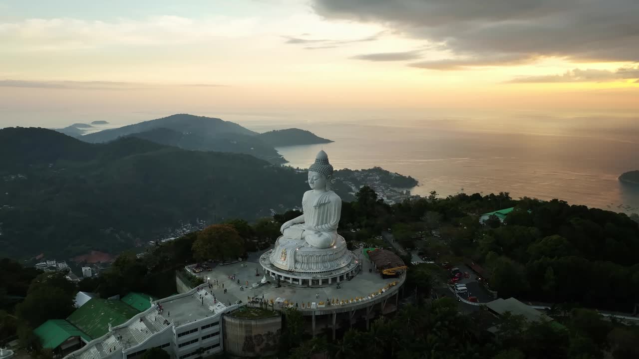 白色大理石大佛雕像寺庙，近距离鸟瞰泰国普吉岛山顶大佛，令人惊叹的日落或日出天空在海上视频素材