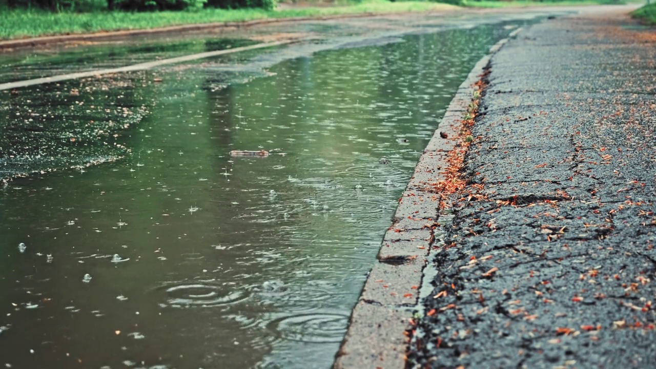 下雨天，脏雨水在路边流动，形成大水坑视频素材