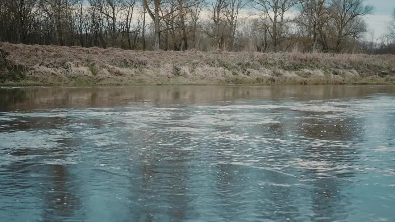 河水的快速流动，树木和天空的背景。视频素材