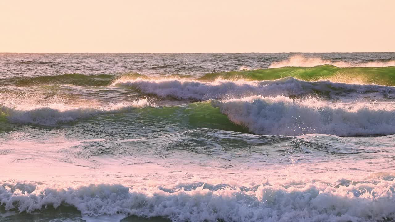 海面上的日出和翻滚的大浪向海边和沙滩冲去视频素材