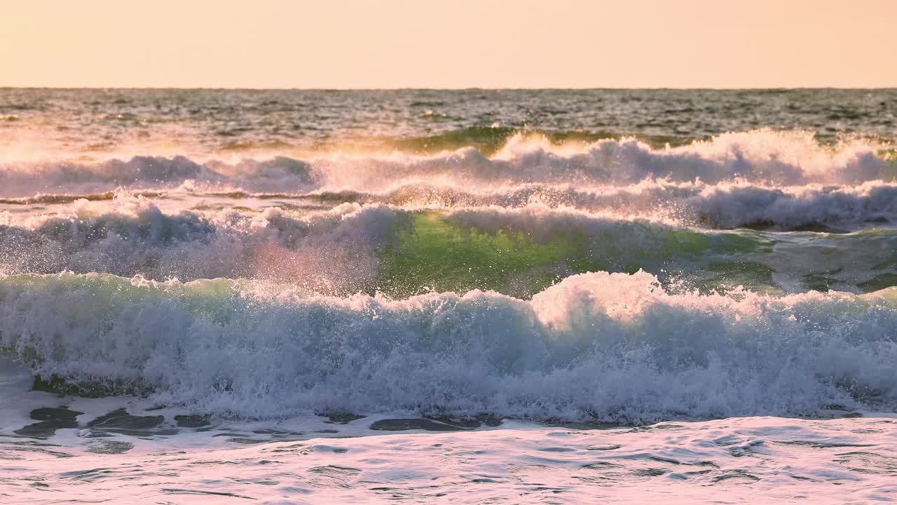 海上日出，翻滚的大浪向海滩和飞翔的自由海鸥，电影般的4k慢动作视频视频素材