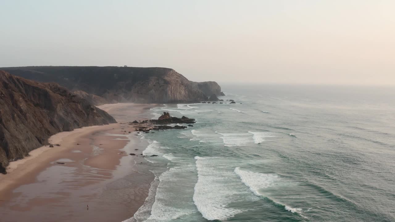 海浪拍打沙滩和悬崖的航拍照片视频素材