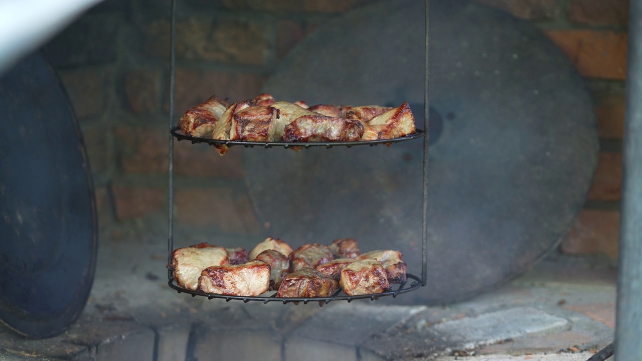 在土灶里的火上煮肉。烤炉里美味的烧烤视频素材