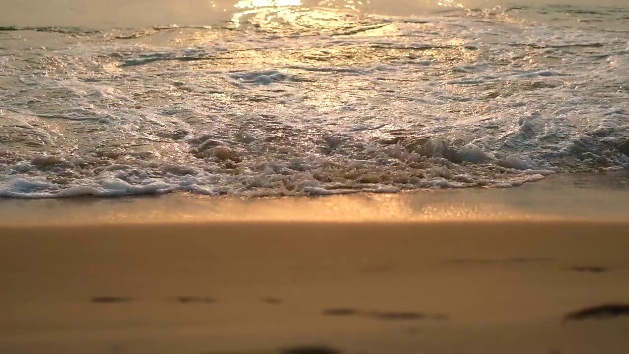 日落时，海浪在沙滩上翻滚，近距离拍摄。冥想自然背景。视频素材